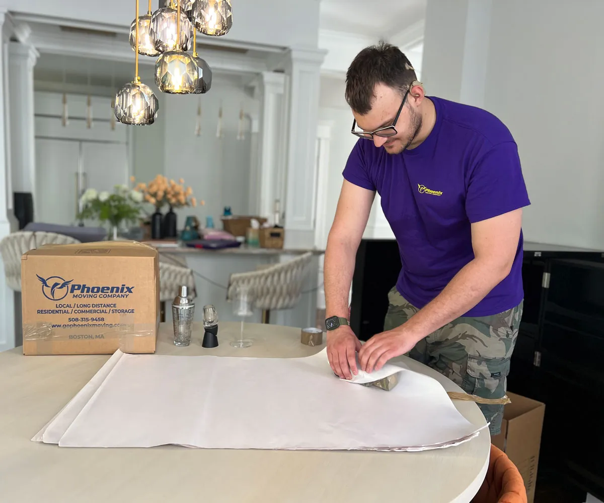 Two movers packing dishes